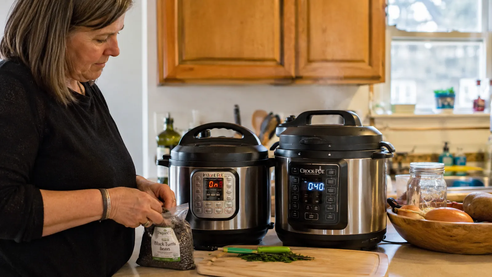 A stainless steel Instant Pot Duo and a black Crock-Pot Express side by side on a home kitchen counter