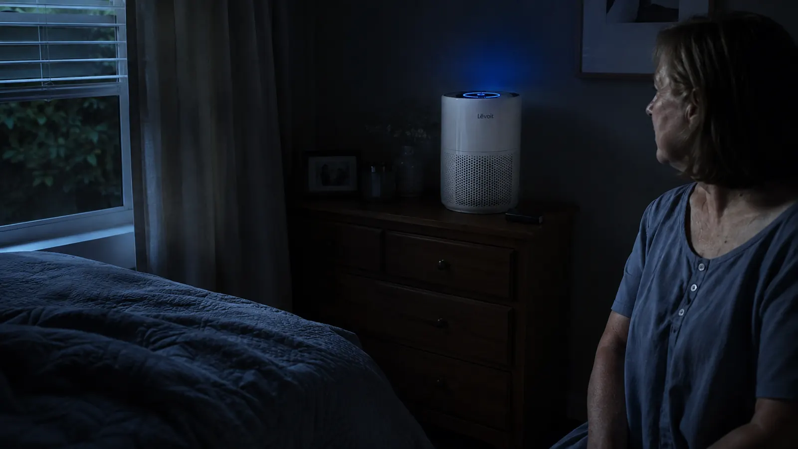 Levoit Vital 200S air purifier glowing softly in a dark bedroom at night